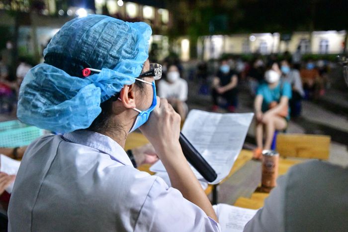 Cán bộ y tế gọi người dân lên lấy giấy chứng nhận đã tiêm vaccine tại phường Trung Văn